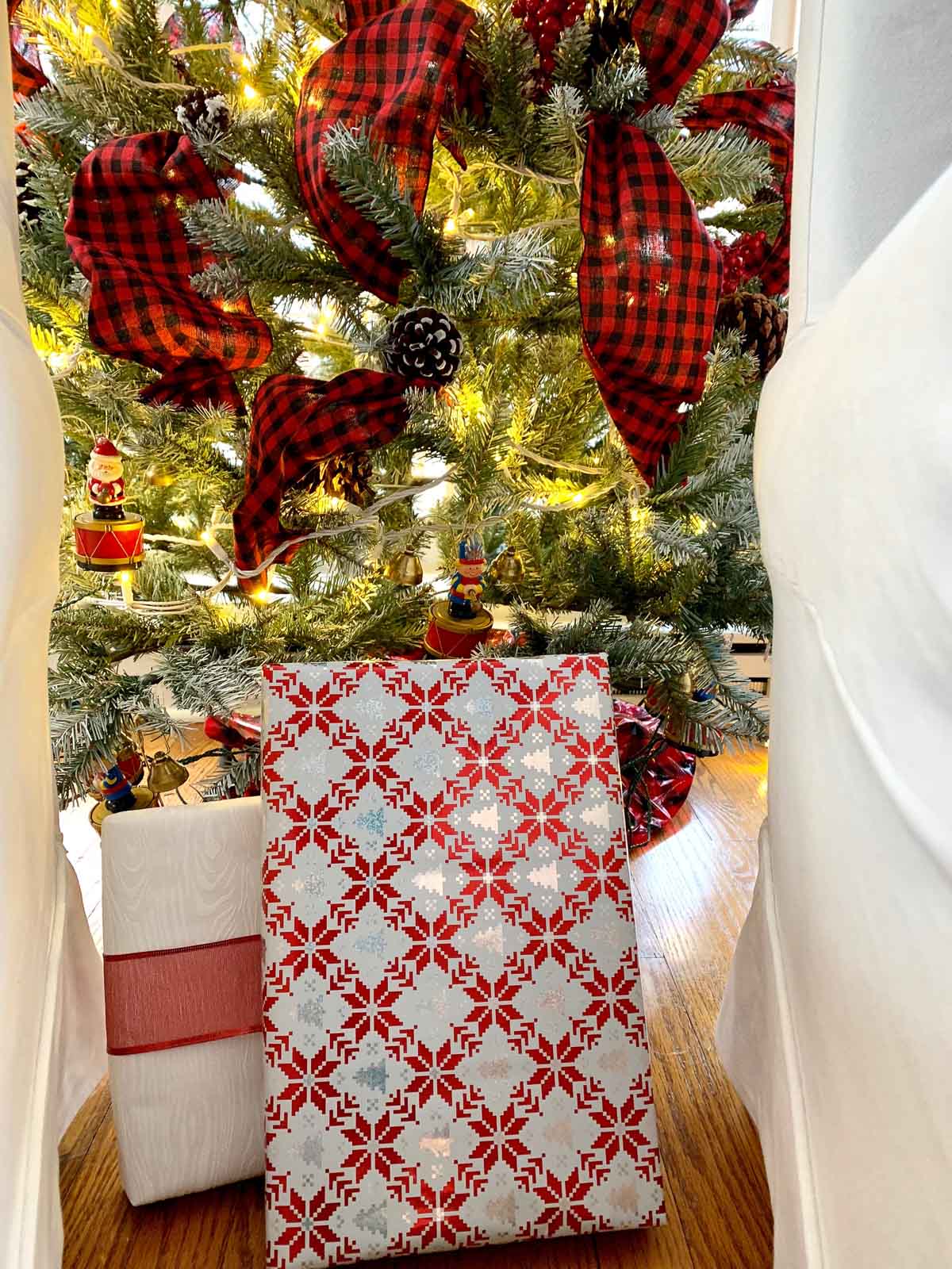 white christmas tree red ribbons white chairs red pillows #christmasdecorating #christmastree